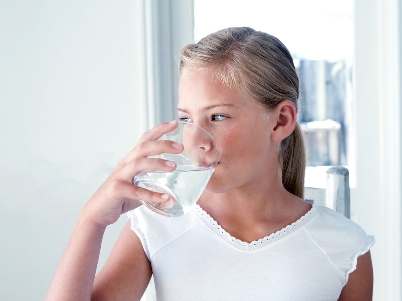 Child drinking clean filtered water at home